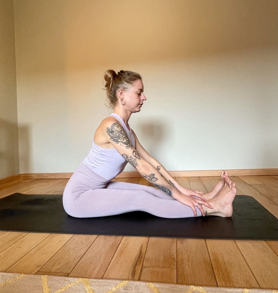 Me demonstrating seated forward fold ~ paschimottanasana: cool down of beginner yoga flow sequence