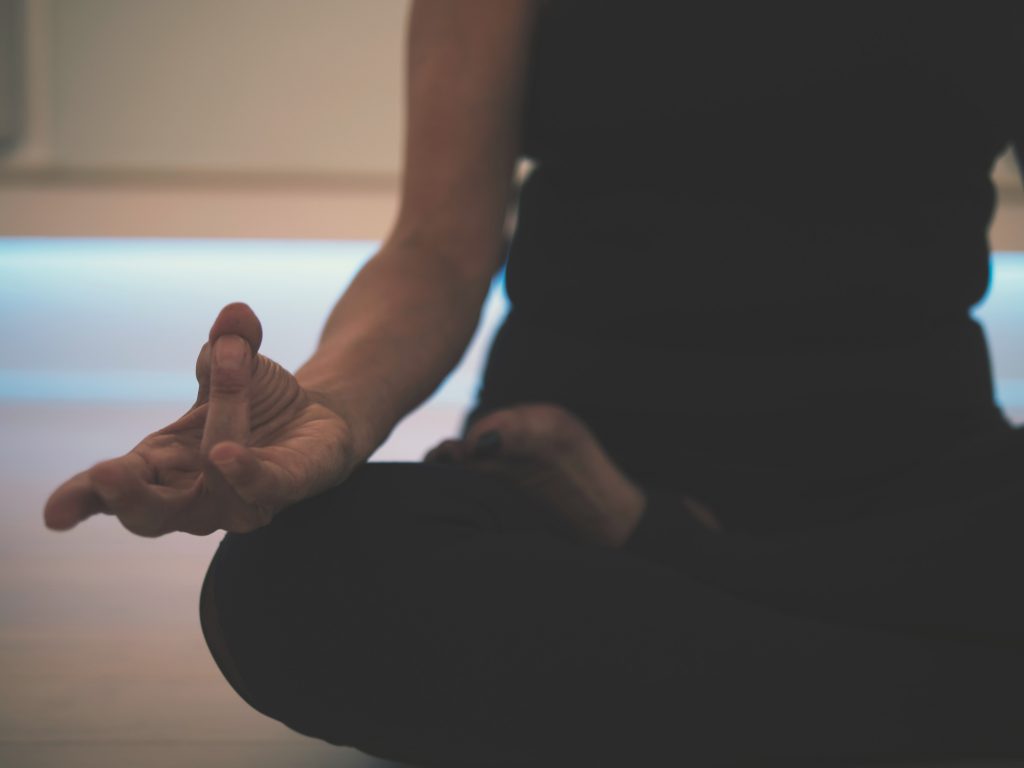 Picture showing a woman in seated meditation for yoga. Seated mediation to start the beginner yoga flow sequence