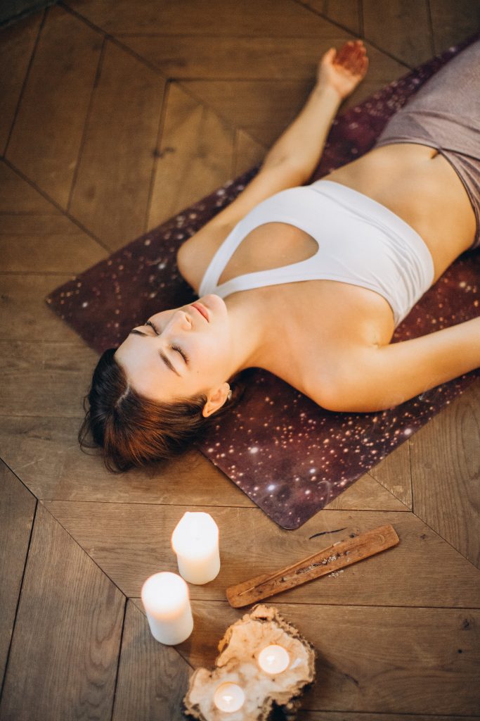 Girl in savasana, also known as corpse pose. This pose ends the beginner yoga flow sequence.