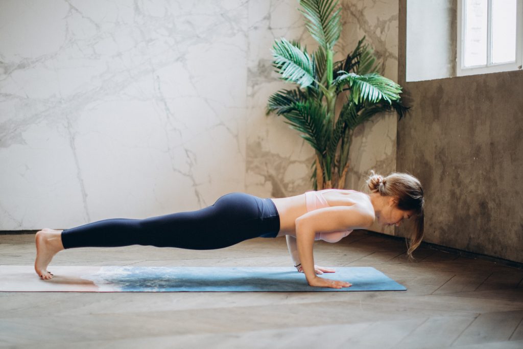 Girl doing the yoga pose chaturanga, which constitutes a vinyasa.