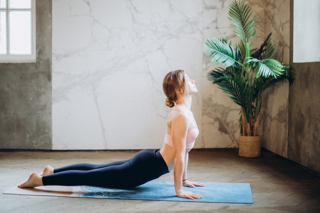 Girl doing the yoga pose upward facing dog, which is part of the vinyasa.