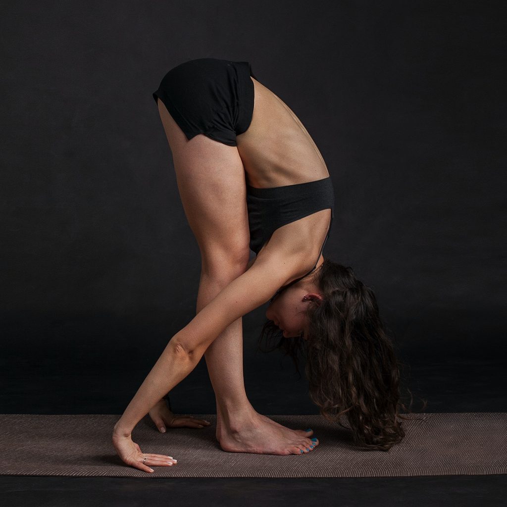 Woman in the yoga pose uttanasana, a standing forward fold.