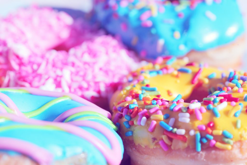 Image depicting bright coloured donuts. These are processed foods and refined sugars. they should be avoided for depression.