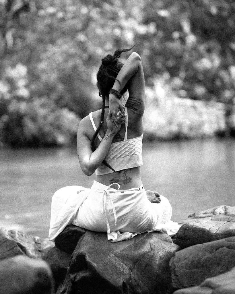 Image depicting woman in lotus pose by the water. Preparatory hip opening poses are necessary to get the body ready for lotus.