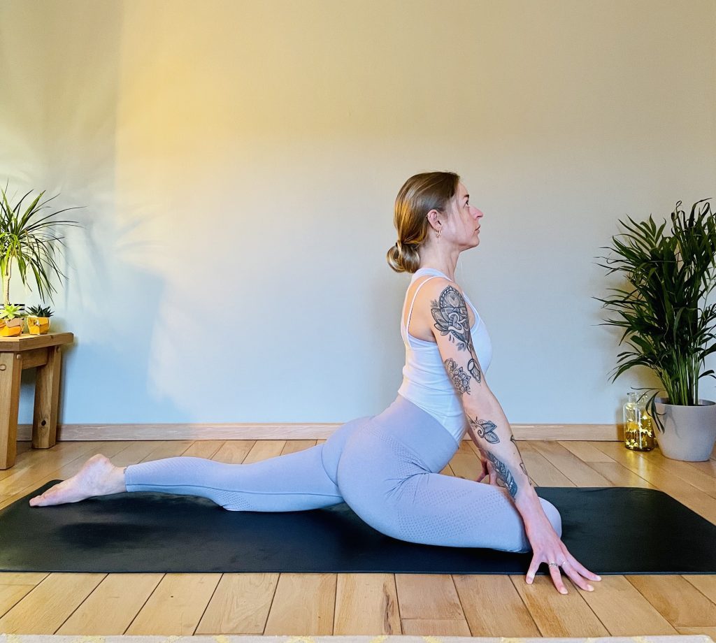 Image showing a girl practicing the yoga pose: pigeon or eka pada raja kapotasana. Pigeon opens the glutes and can greatly help in reducing lower back pain.