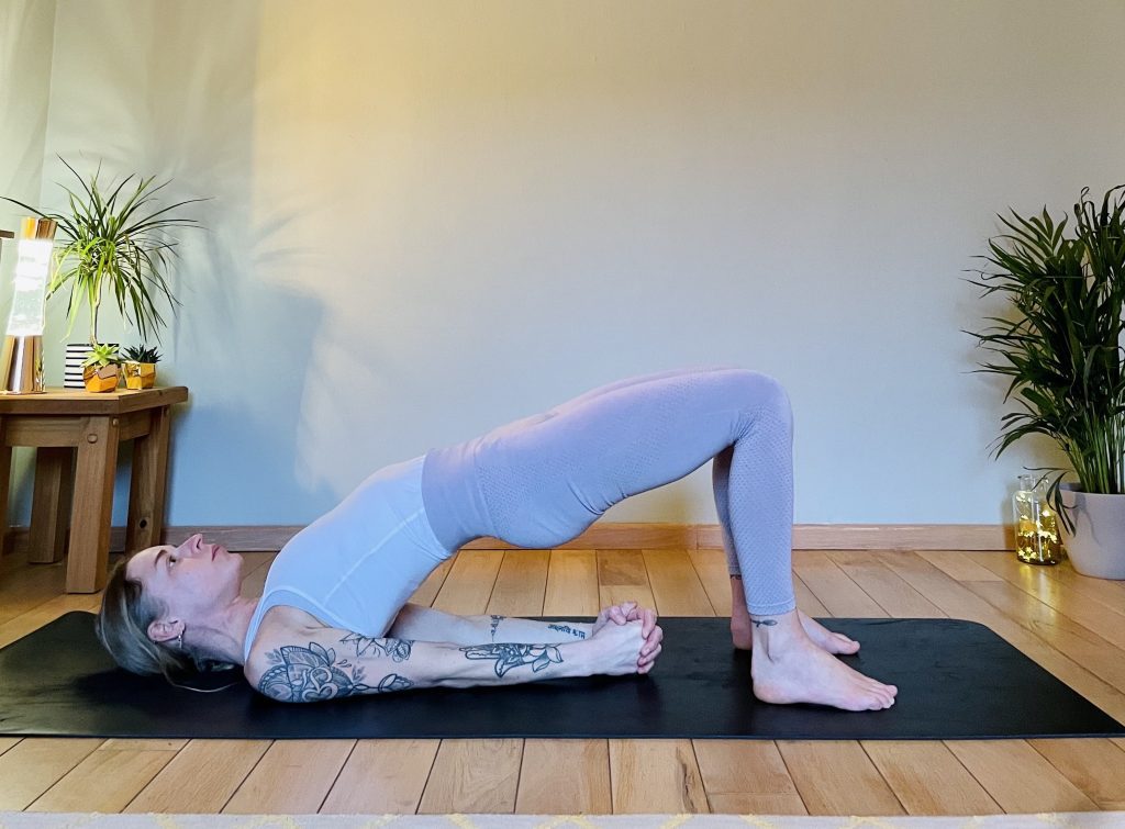 Image showing a girl practicing setu bandha - bridge pose in yoga. Bridge pose strengthens the hamstrings, glutes, and lower back and helps protect the lumbar spine.