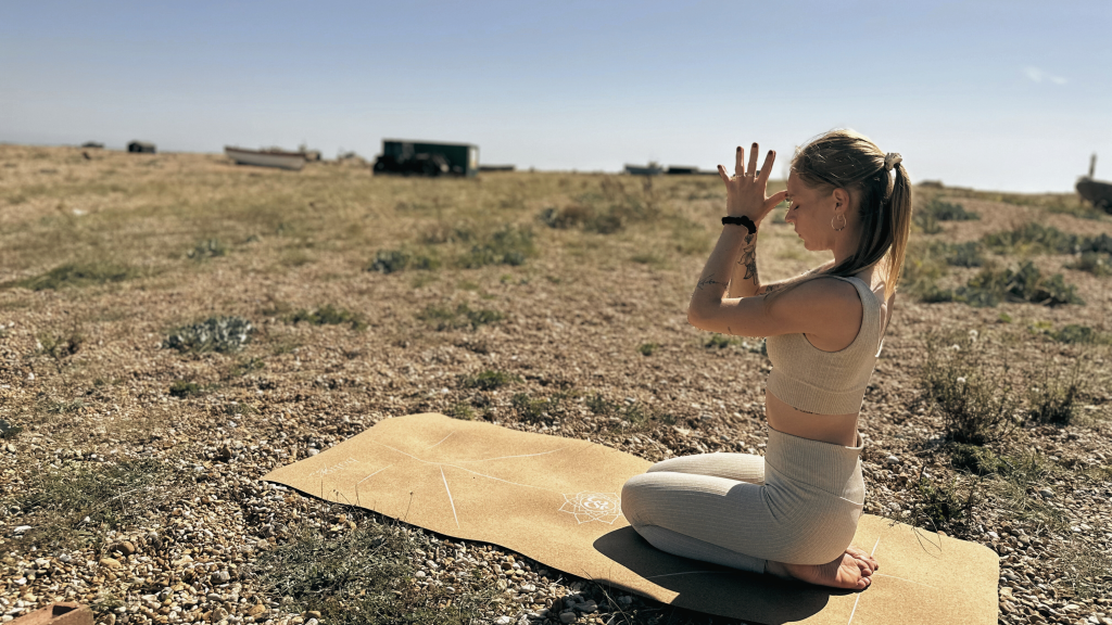 Picture showing young girl in a meditative yoga pose. It reflects the idea of movement, breath, and meditation, which are all crucial aspects of self-care.