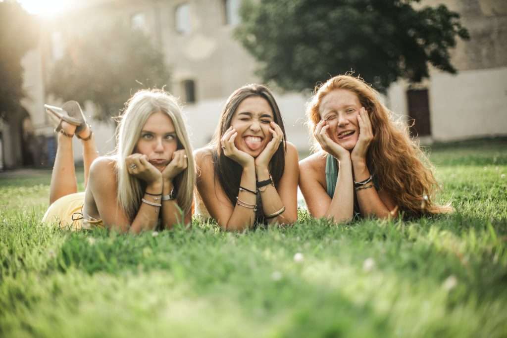 Picture showing three young girls pulling funny faces. Quality social time is part of the social self-care practice.